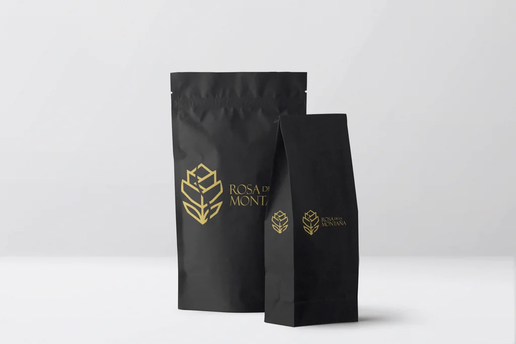 Bolsas de café negras con el logotipo en dorado.